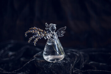 miniature decorative vase on black background, bottle vase in the shape of an angel with dry lavender, cute glass vase with lavender flowers, glass angel with wings