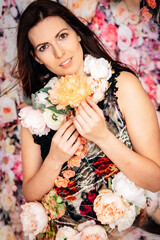 Pretty woman with flowers. Brunette girl with flower dress on a flower background sexy colourful