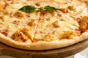 Pizza Margherita with mozzarella and basil leaves on wooden stend. Traditional italian food