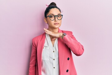 Beautiful middle eastern woman wearing business jacket and glasses cutting throat with hand as...