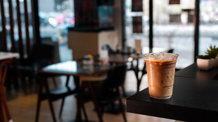 Close-up glass of iced coffee with milk on the table