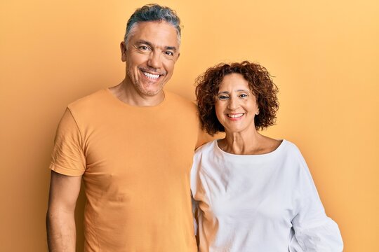 Beautiful middle age couple together wearing casual clothes with a happy and cool smile on face. lucky person.