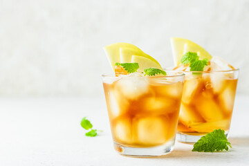 Summer refreshing drink, apple iced tea in glasses. Space for text.