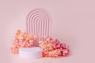 Textured  arch  with podium and  flowers on a pink background.  Stylish  background for cosmetic product presentation