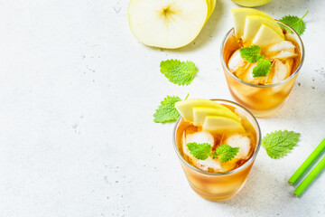 Apple summer refreshing ice mocktail, apple iced tea in glasses. Space for text, top view.