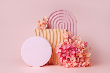 Pink arch, wooden plate with waves and flowers with circle on a pink background.  Stylish background with various materials and geometric shapes