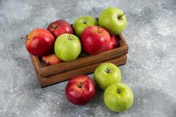 Bunch of fresh green and red apples placed in wooden box