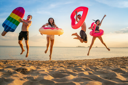  Holiday summer party with friends on the beach .Group of family and friends  jumping on the beach. lifestyle people vacation holiday on beach