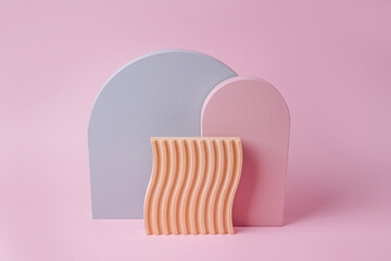 Gray and pink arches and wooden plate with waves  on a pink background. Stylish background with various  geometric shapes