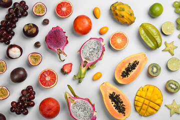 Many different delicious exotic fruits on light background, flat lay