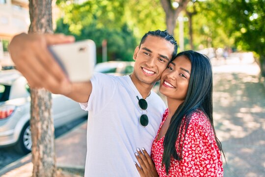 Young latin couple smiling happy making selfie by the smartphone at street of city.