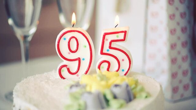 Birthday candle as number ninety five 95 on top of sweet cake on the table, 95th birthday, HD
