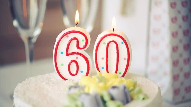 Birthday candle as number sixty 60 on top of sweet cake on the table, 60th birthday, toned video