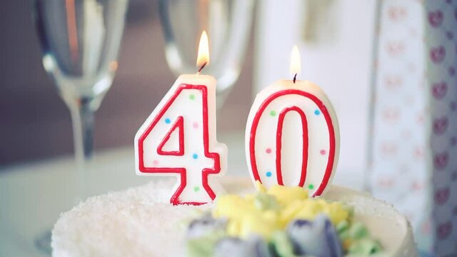 Birthday candle as number forty 40 on top of sweet cake on the table, 40th birthday, toned video