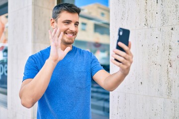 Young caucasian man smiling happy doing video call using smartphone at the city.