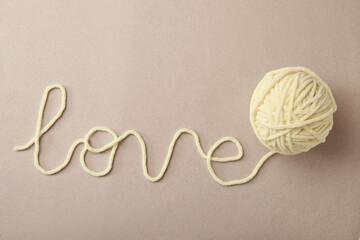 Word Love made of woolen yarn on grey background, top view
