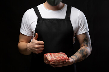 A butcher wearing apron uniform with a piece of pork rib showing thumbs up.