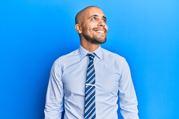 Hispanic adult man wearing business shirt and tie looking to side, relax profile pose with natural face and confident smile.