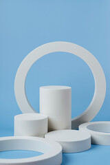 White podium to show cosmetic products with geometric forms on blue background. Background for branding and packaging presentation. Natural skincare beauty product concept.