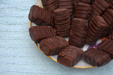 Chocolates are on a plate. Blue background.