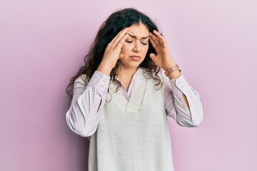 Young brunette woman with curly hair wearing casual clothes with hand on head, headache because stress. suffering migraine.