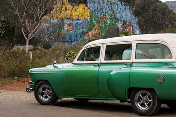 Old american car with colourful mural wall from Vinales, Cuba