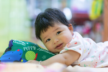 Asian Happy baby crawling and playing with educational toys on the bed. Cute baby smiling and playing toy use as baby development and education concept.