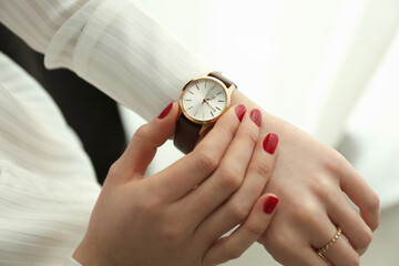 Woman wearing luxury wristwatch indoors, closeup of hand
