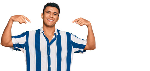 Young arab man wearing casual clothes looking confident with smile on face, pointing oneself with...
