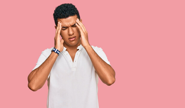 Young arab man wearing casual clothes with hand on head, headache because stress. suffering migraine.