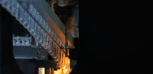 PET Preform in PET bottles blow molding machine in factory with copy space. Technology in plastic bottles machine for industry, Industrial and factory concept.