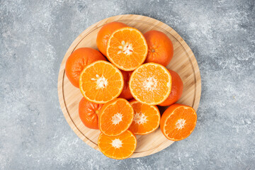 Sliced juicy fresh orange fruits in a wooden plate