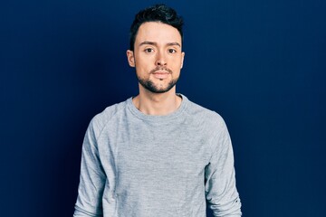Fototapeta premium Young hispanic man wearing casual clothes relaxed with serious expression on face. simple and natural looking at the camera.