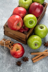 Whole delicious green and red apples in wooden box
