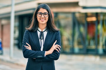 Fototapeta premium Young hispanic businesswoman smiling happy standing at the city.