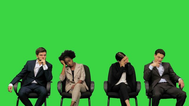 Conference participants looking tired and bored, yawning, fidgeting on their seats on a Green Screen, Chroma Key.