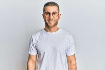 Obraz premium Young caucasian man wearing casual clothes and glasses with a happy and cool smile on face. lucky person.