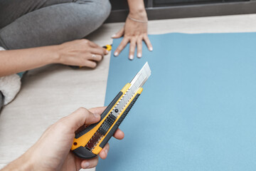 stationery knife to cut wallpaper on the floor during the renovation of the house