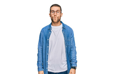 Fototapeta premium Young caucasian man wearing casual clothes making fish face with lips, crazy and comical gesture. funny expression.