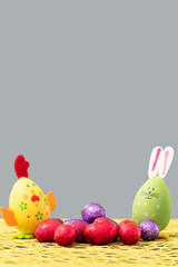 décoration de pâques lapin et poule de pâques devant un fond gris pantone couleur de l'année photographié en format portrait