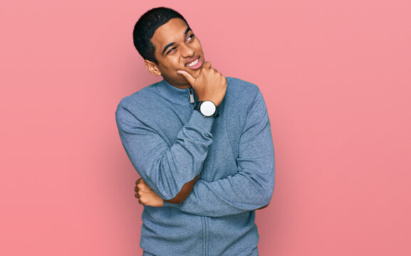 Young handsome hispanic man wearing casual sweatshirt thinking worried about a question, concerned and nervous with hand on chin