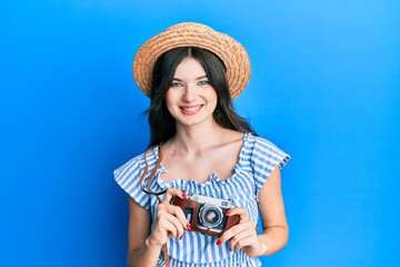 Young beautiful caucasian girl holding vintage camera smiling with a happy and cool smile on face. showing teeth.
