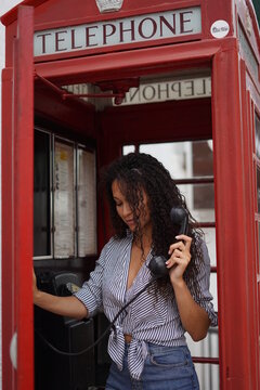 Modelo brasileña hablando desde una cabina telefonica