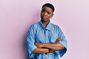 Young african american woman with arms crossed gesture skeptic and nervous, frowning upset because...