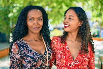 African american mother and daughter smiling happy hugging at the park.