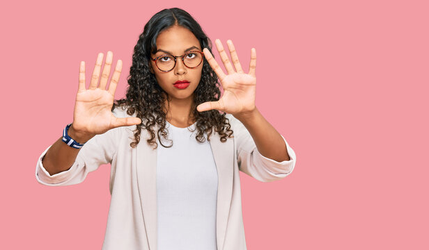 Young african american girl wearing business clothes doing frame using hands palms and fingers, camera perspective