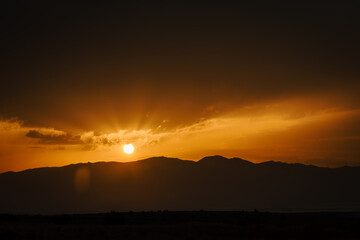 Fototapeta na wymiar Sol poniéndose sobre las montañas del Parque Natural de Cabo de Gata Nijar. Puesta de Sol en verano