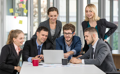 Group portrait of businesspeople team sitting in conference together in an office with intimate and excited the success on laptop computer sreen. Idea for a good relationship of teamwork in business