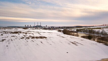 Aerial view of power station in evening light. Early spring urban industrial landscape. Snow melting, Season change