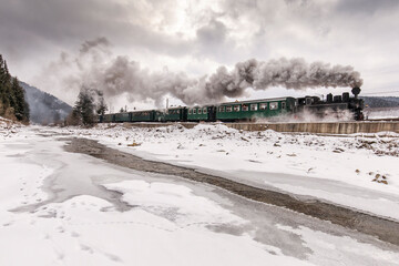 Old train with big smoke during winter time in Moldovita, Bucovina. Romaniia.